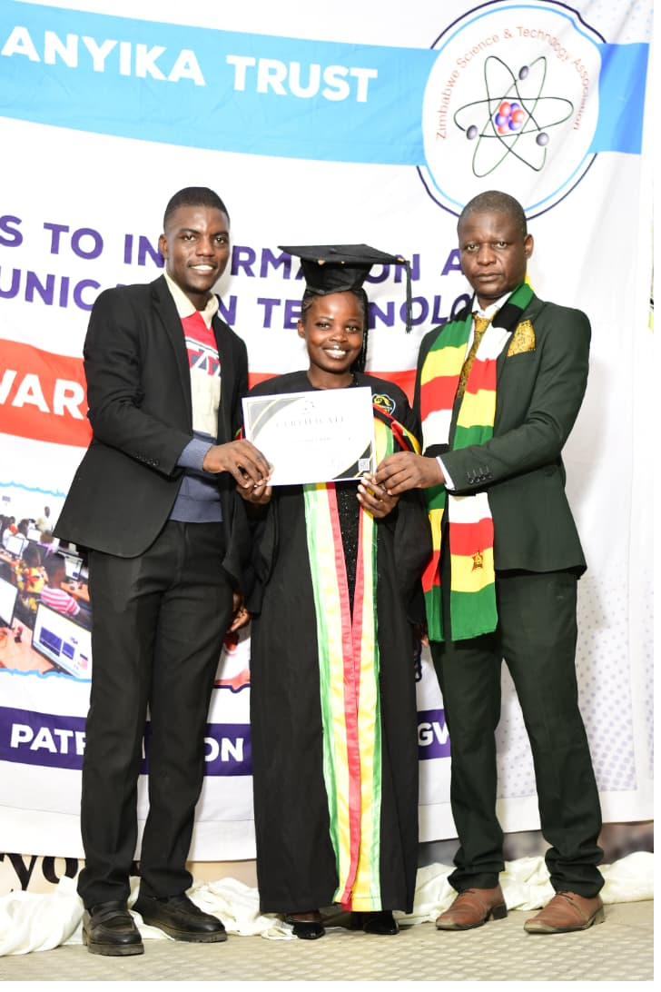 Graduate receiving a certificate from two officials